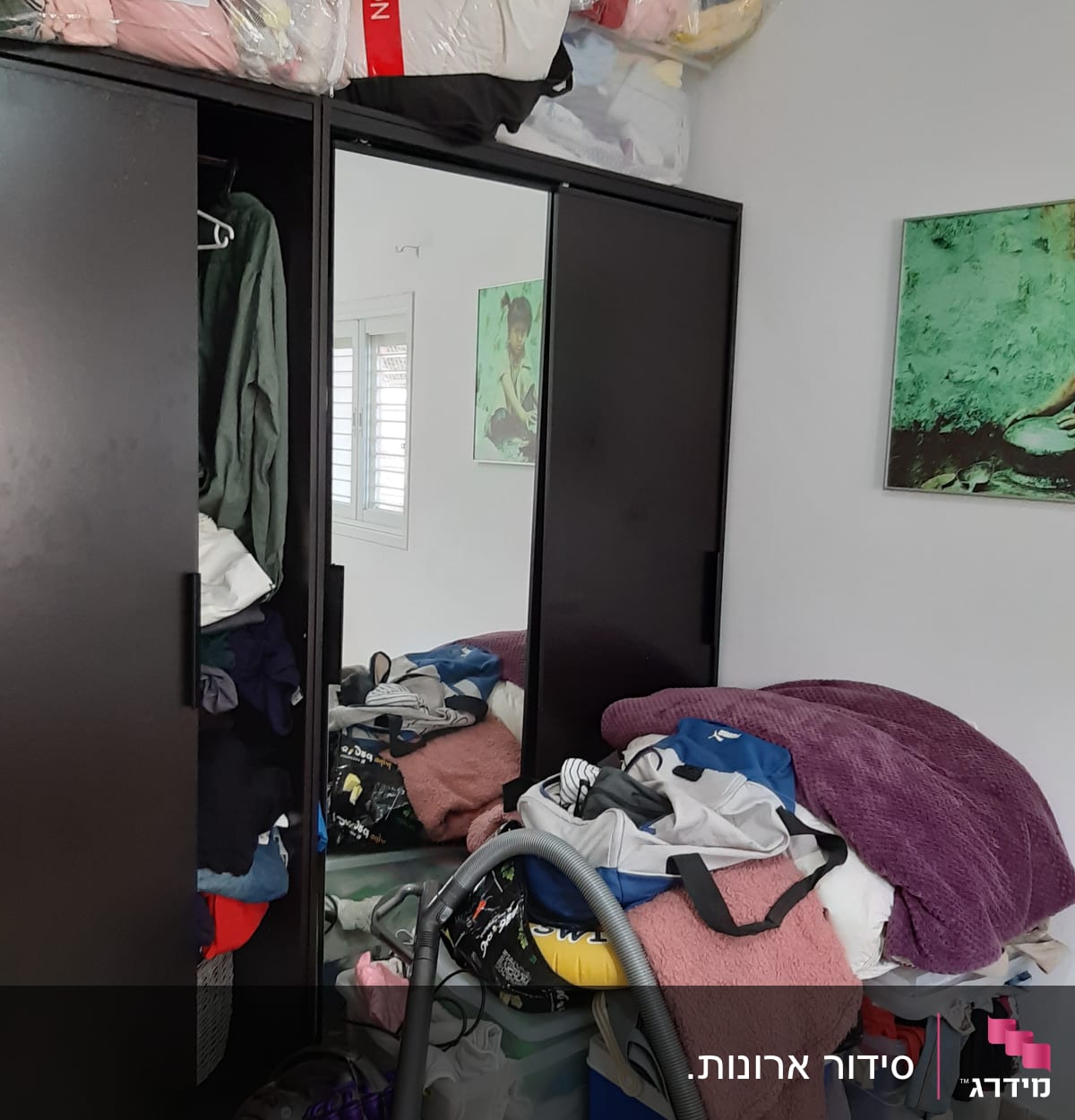 ארון בגדים עם בגדים מקופלים ושואב אבק על הרצפה